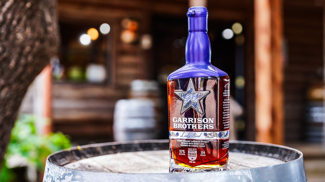 Garrison Brothers Lady Bird bottle on an oak barrel at the distillery